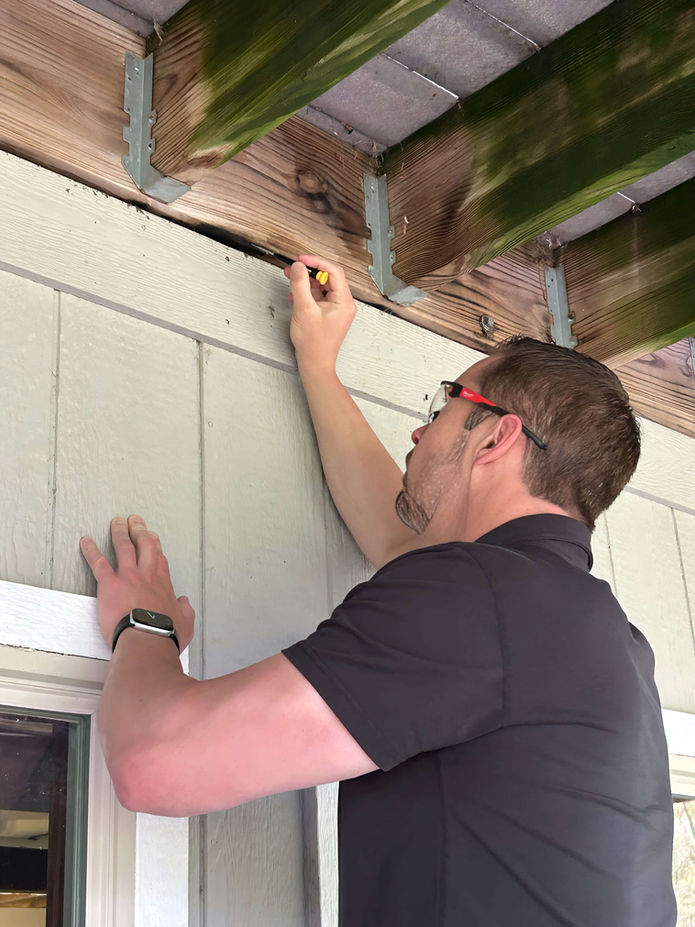 Wolf’s Home Inspections performing a deck inspection outside of a Topeka home.