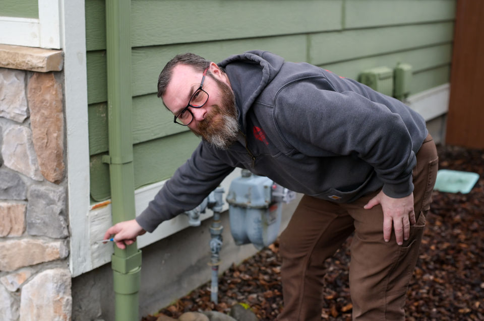 Thomas Winkler inspecting siding
