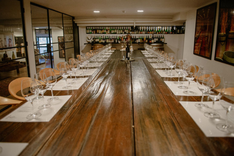 טעימת יין: שולחן ארוך מעץ, כוסות וכיסאות