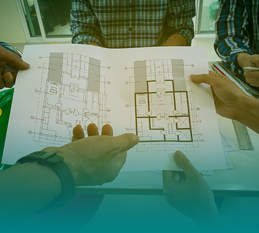 Contractors reviewing architectural floor plans on a job site