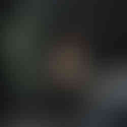 Overhead view of an orange car on a gritty road with orange, grey, and white painted sections.