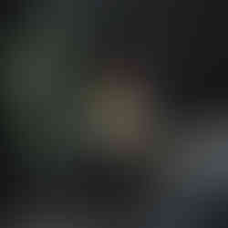 Girl with long hair sitting on a red bench holding a balloon under colourful cloud splashes