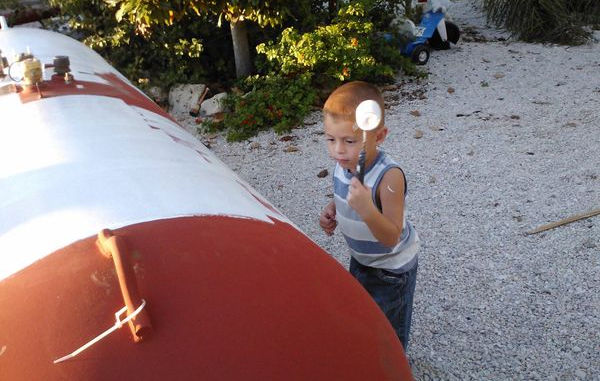 Tejas Propane family member painting an aboveground propane tank