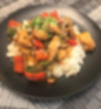 Chicken stir-fry with peppers and sesame seeds over rice