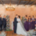 Couple's first kiss at an indoor ceremony in the Brick Room at The Broz Event Venue