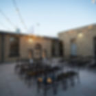 Ceremony chairs set up on the brick courtyard patio at The Broz Event Venue