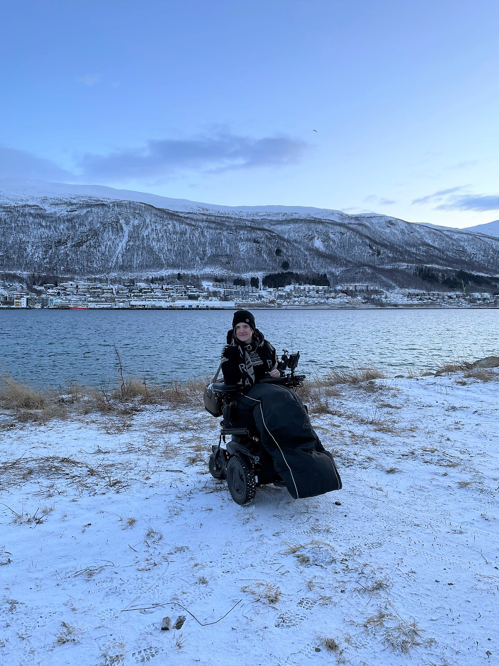 Ingrid er ute, det er snø på bakken og Trømsø i bakgrunnen
