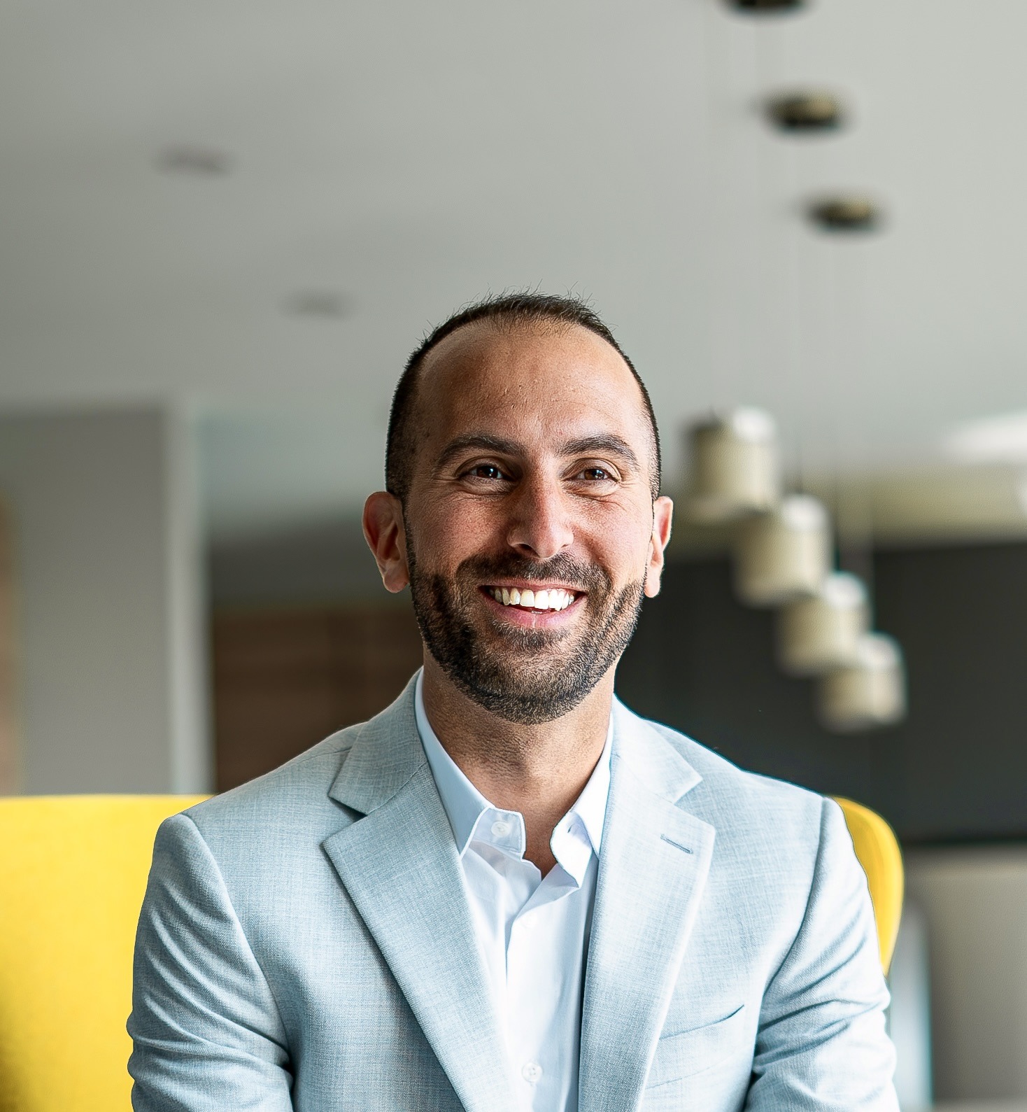 Charbel Daniel smiling, in a light blue blazer and white shirt