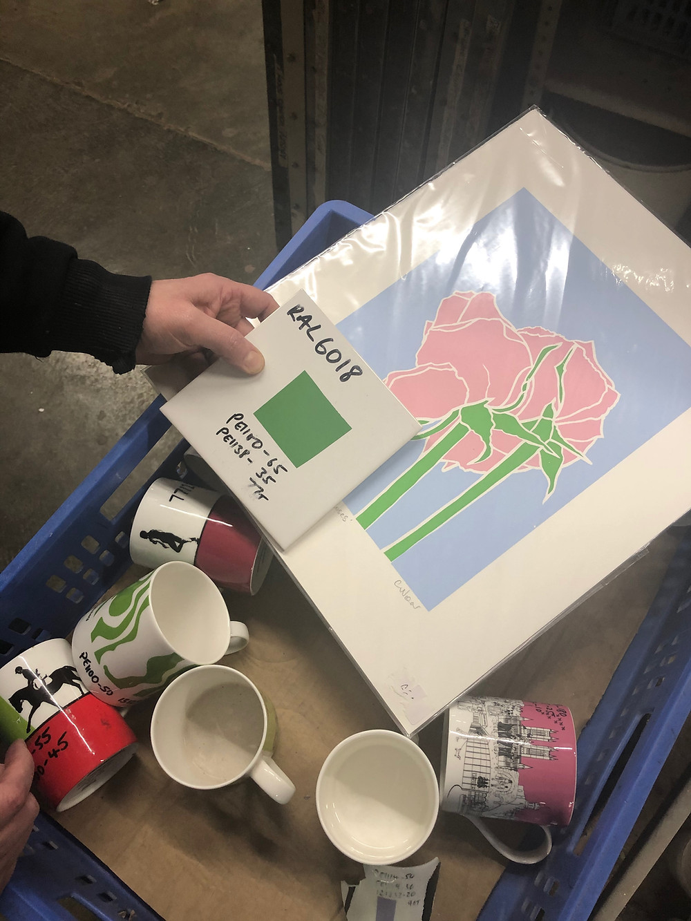 holding colour samples against an art print