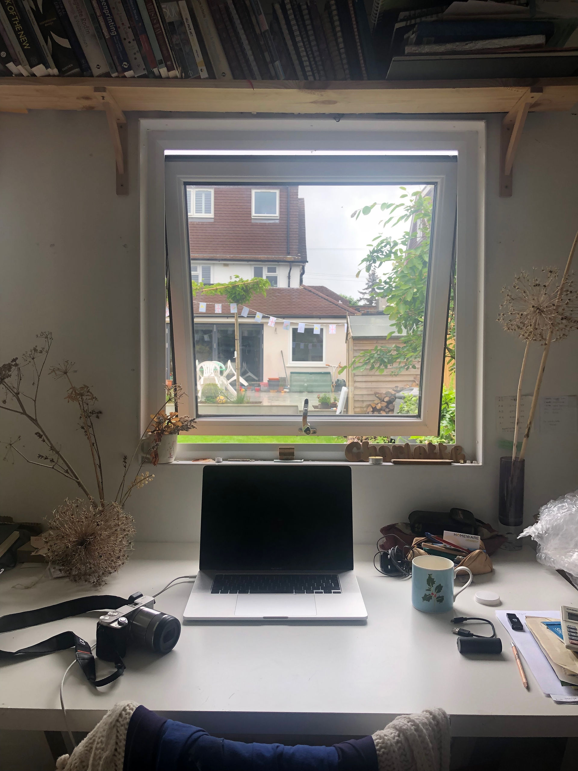 Looking from a desk with laptop through the window to a garden