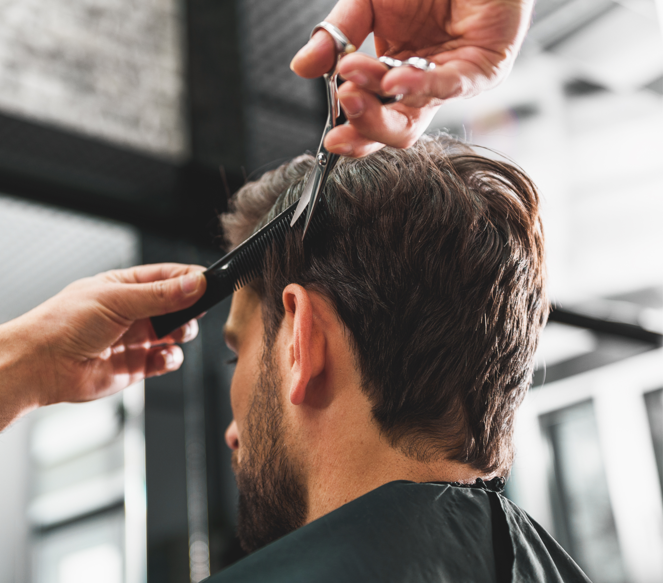 Friseur schneidet einem Mann die Haare.