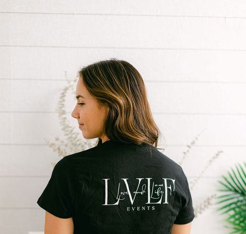 The back of a Love and Life Events shirt, proudly displaying the team's name during wedding setup.