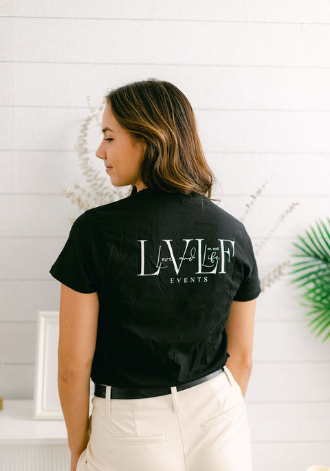 The back of a Love and Life Events shirt, proudly displaying the team's name during wedding setup.