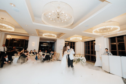 Bride and groom sharing their first dance as husband and wife while family and friends cheer