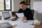 Property investor reviewing rental property financial documents at a desk with invoices, receipts, and reports, illustrating hidden property management fees affecting rental property profitability.