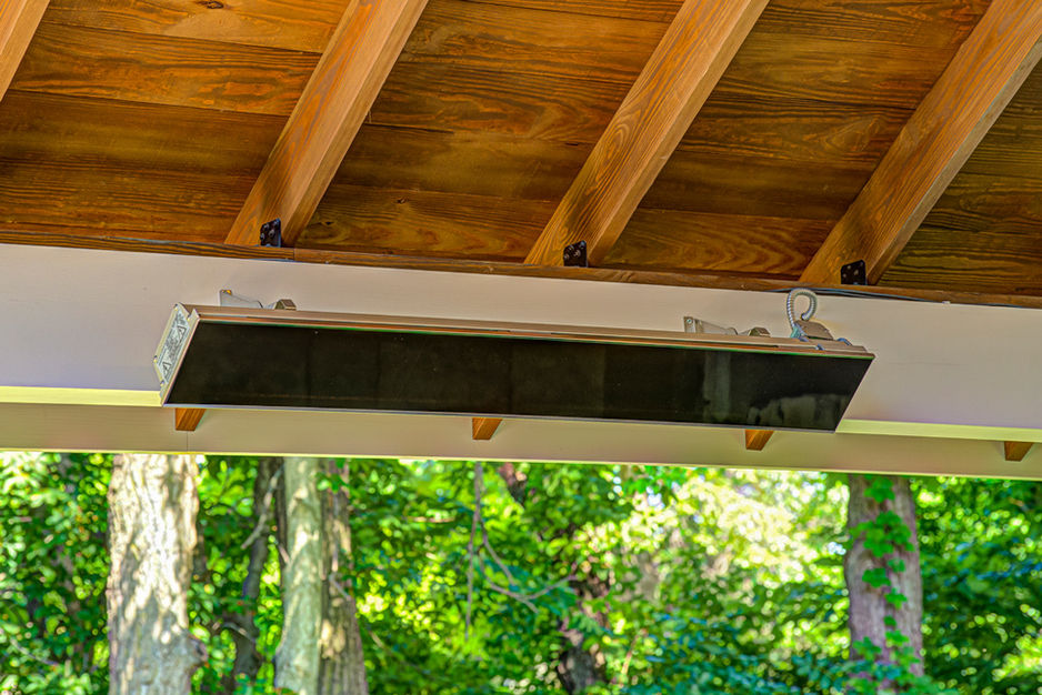 Outdoor patio heater mounted beneath wood pavilion ceiling.