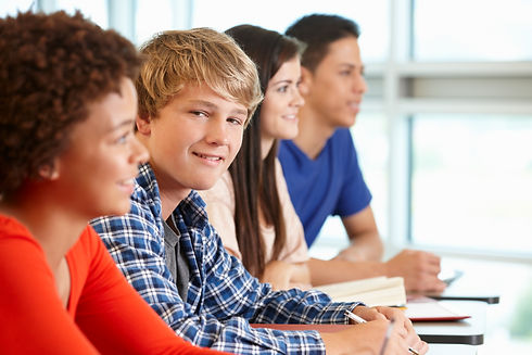 Multi-racial-teenage-pupils-in-class,-one-smiling-to-camera-184921889_5616x3744.jpeg