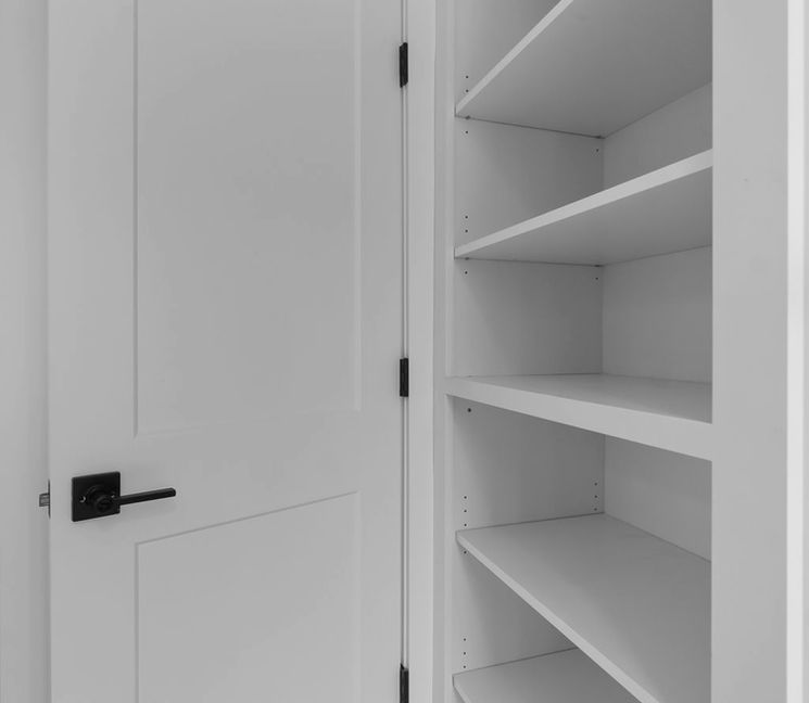Open white door next to built-in shelves