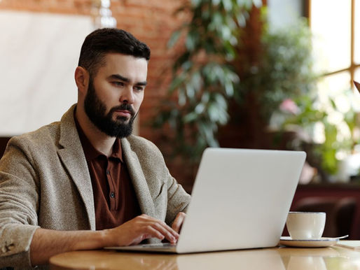 Restaurant owner reviewing a website on a laptop at a table