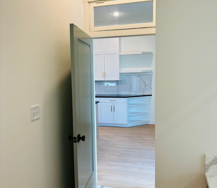 Open door to kitchen area with checkered floor