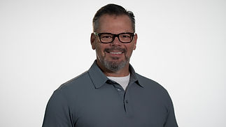 Smiling man in glasses, gray polo shirt