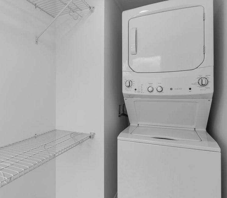 Laundry area with stacked washer dryer and patterned floor