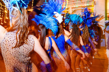 Dancers in blue feathered costumes at a festive event