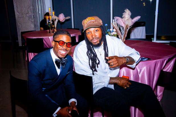Two men smiling, posing at an event with pink tablecloths, ATX Event Photography.
