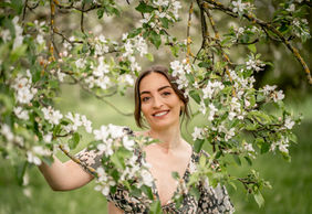 Porträt einer Frau zwischen blühenden Apfelbäumen – Frühlingshafte Fotografie von Fotografin Aschaffenburg, Miltenberg und Rhein-Main.
