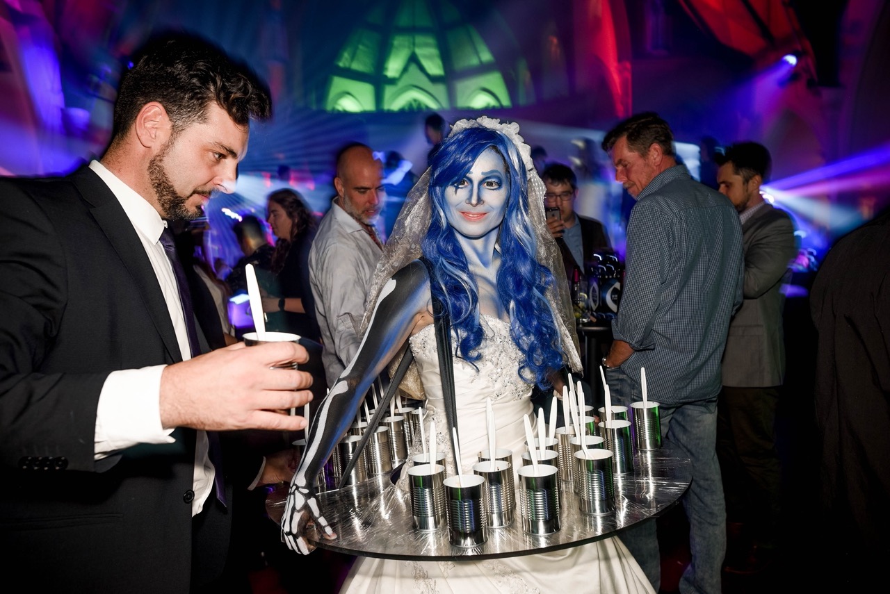 Service de nourritureavec plateau ambulant Mariée Cadavérique avec robe champagne animation Tim Burton captivant le public lors d’un événement corporatif ou privé Québec