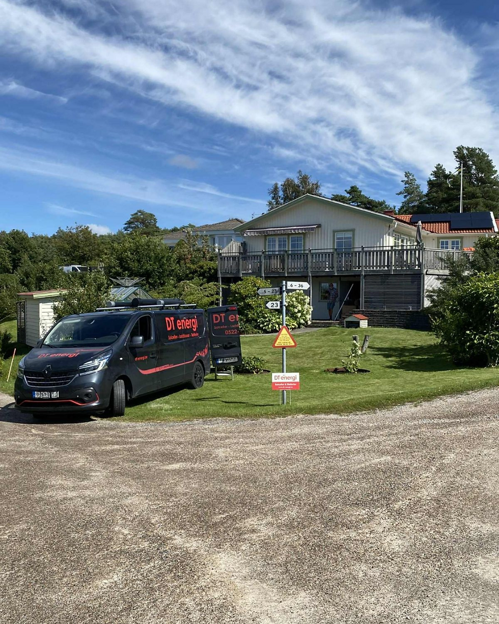 Bild av DT energi bilen parkerat på gräset framför en kunds hus