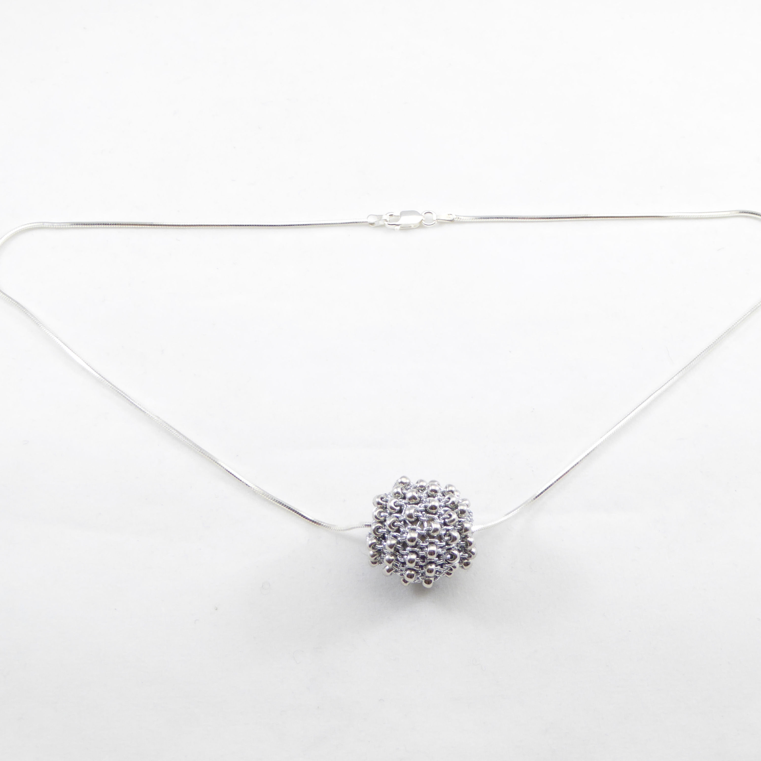 Urbanknits silver hand-knit beaded ball on an Italian sterling silver chain.
