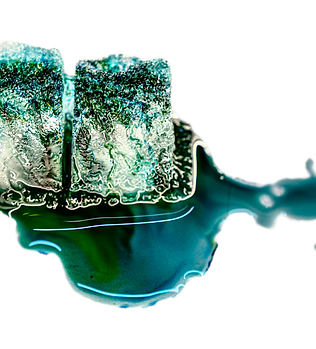 Ice cubes melting with green dye.