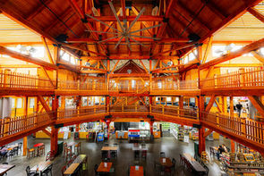 Interior of Southgate Crossing in Elkhart, Indiana, showing the large Amish built peg and beam market hall with wood balconies, vendor booths, and seating below.