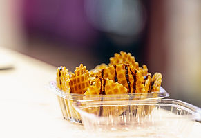 Plastic tray of ice cream nachos made with waffle cone chips and chocolate drizzle.