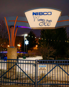 Entrance sign for NIBCO Water and Ice Park at night, with the rink gate and illuminated signage visible.