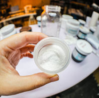 Small container of soda ash powder being added to a custom ice dye mixture.