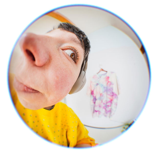 Fisheye photo of Corky Lorenz looking at a tie dyed shirt in the background.
