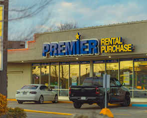 Premier Rental Purchase store in downtown Elkhart, with parked cars in front of the building.