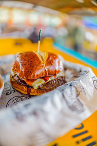 Hamburger with cheese oozing out.