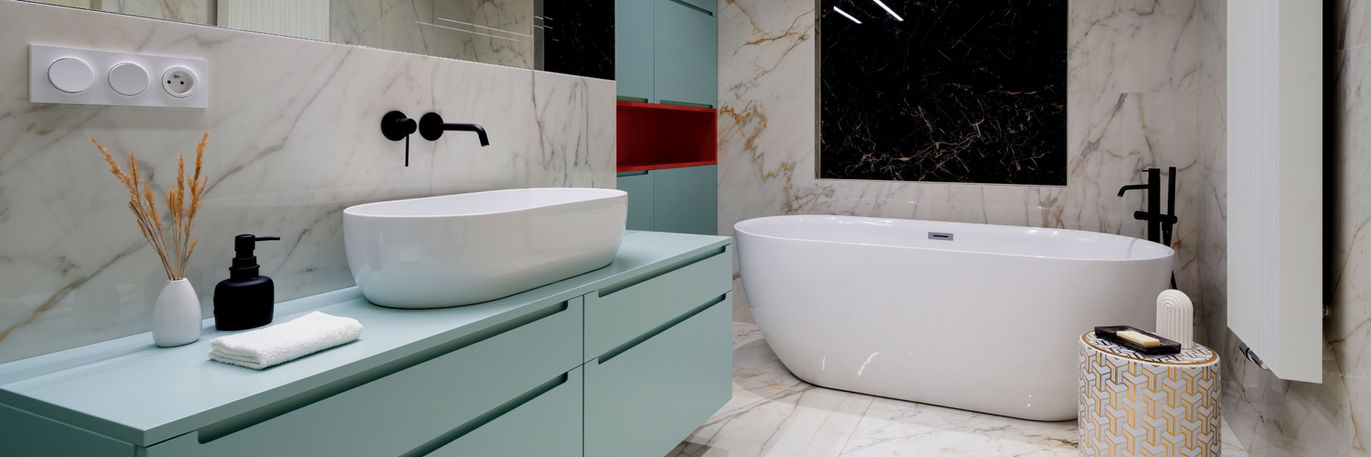 beautiful bathroom remodel in west palm beach with tiffany blue flat panel custom cabinets and white stand alone tub and black fixtures.