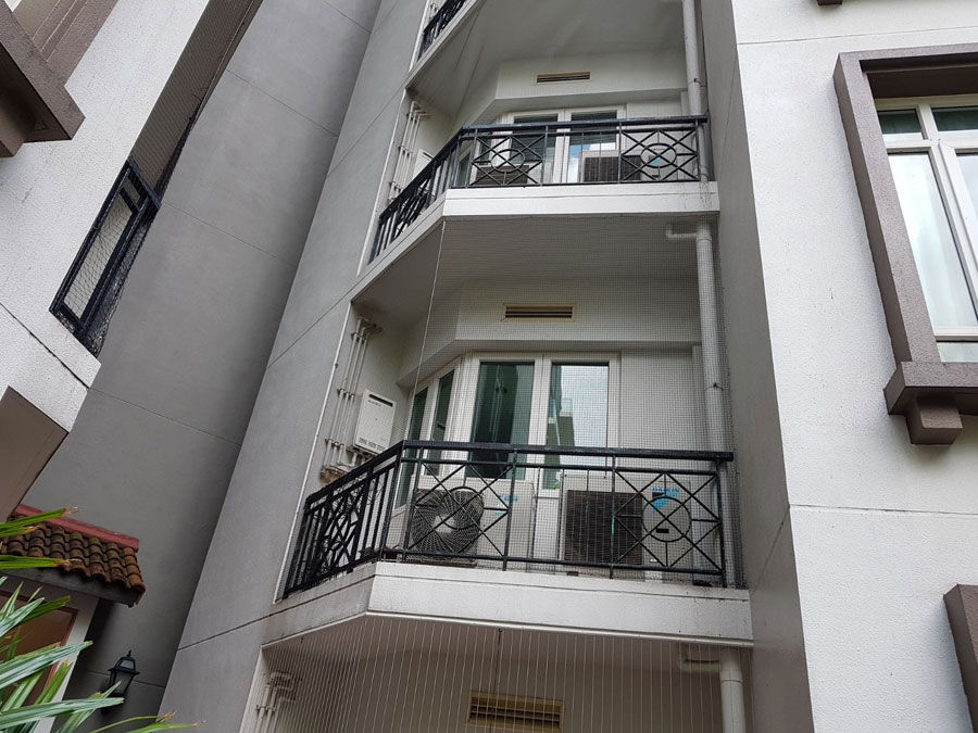 Professionally installed UV-resistant bird netting on HDB aircon ledge in Singapore protecting outdoor condenser unit from pigeons and pests