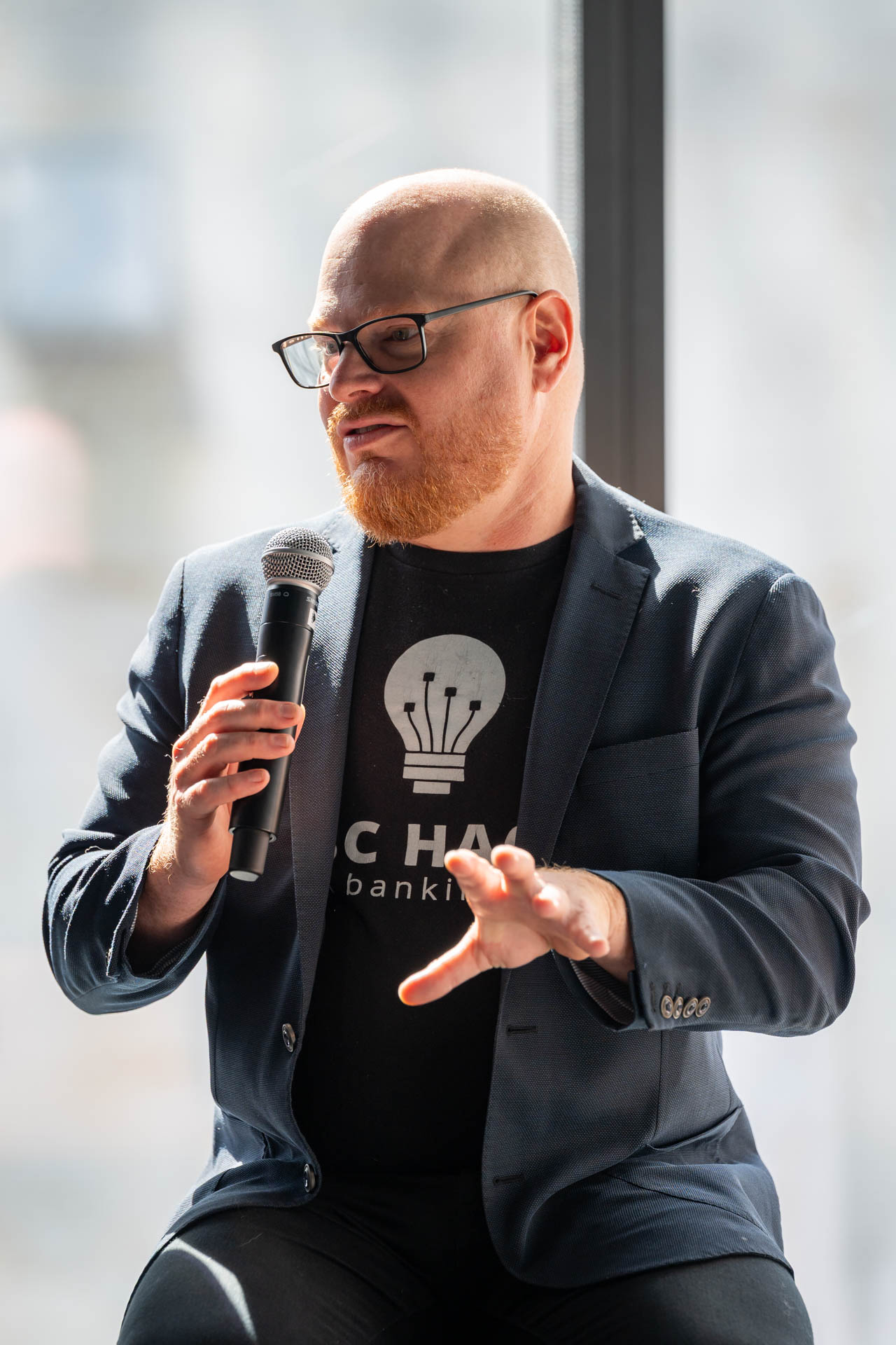 Man speaking at an event with a microphone