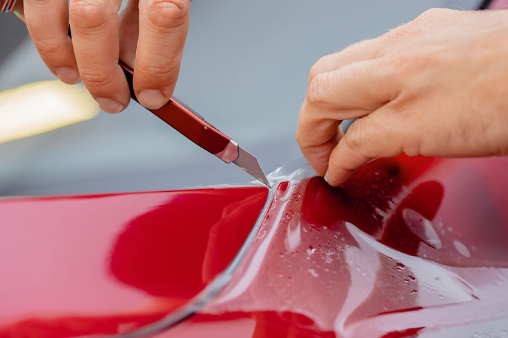 Master man installs vinyl film protect arches of doors car body paint..jpg