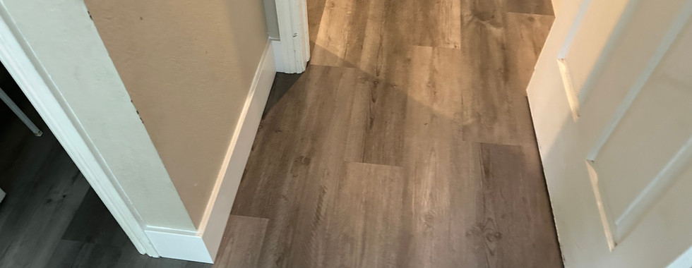 Completed gray vinyl plank flooring in a well-lit, modern space