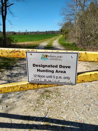 A sign on a gate that says designated Dove Hunting area