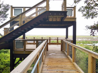 A close up look of a two story observation deck with a wetland in the background