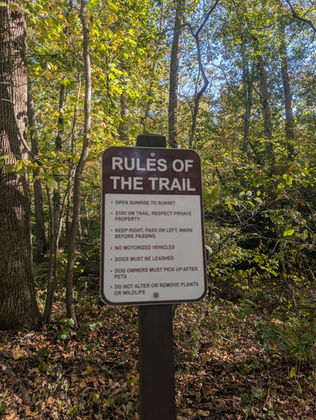 A sign in the woods explains the rules of the trail