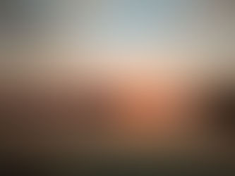 a kayaker paddles into the sunset on calm water and trees in the background