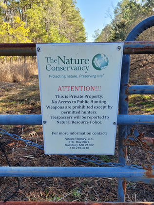 A sign about the Nature Conservancy mounted on gate